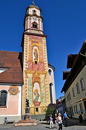 Oberbayern - Einmalig: Der barocke Mittenwalder Kirchturm ist der einzige mit Lüftlmalereien. Sie zeigen die Patrone Petrus und Paulus auf Podesten