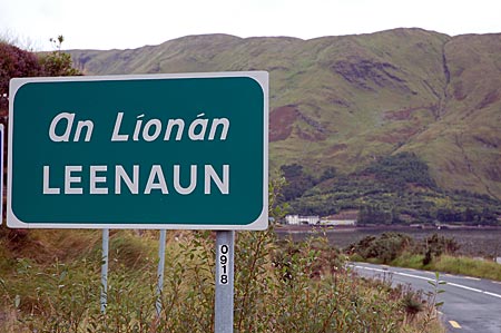Ortsschild von Leenaun, An Líonán ist die gälische Version. Im Hintergrund das Dorf, das am Kopf vom Killary Harbour liegt, des einzigen Fjords Irlands, Connemara, Co Galway, Westirland