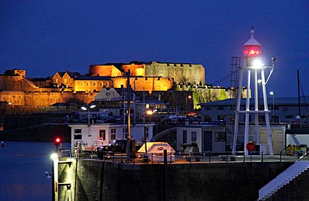 Guernsey - Der Hafen von St. Peter Port und Castle Cornet in der Abenddämmerung.