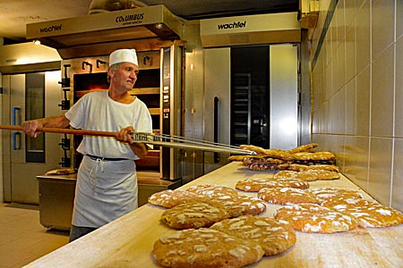 Italien - Vinschgau in Südtirol - Bäcker Andreas Pilser, der Kortscher Bäck, in seiner Backstube (das Urpaarl wird in den Backofen geschoben und wieder herausgenommen)