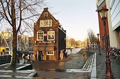 Amsterdam - Hier scheint sogar das Haus zu schwanken: „De Sluyswacht“ (von 1695). Wo früher der Schleusenwächter seinen Dienst tat, befindet sich ein beliebtes Bruin Café (vis-a-vis vom Rembrandthaus)