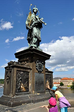 Tschechien - Prag - Die Statue des Hl. Nepomuk auf der Karlsbrücke. Messingplatten erzählen seine Geschichte. Wenn man den stürzenden Märtyrer mit den Fingern berührte, bringe es Glück, sagen die Prager.