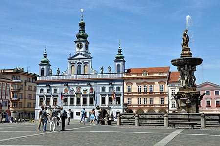 Marktplatz von Budweis mit dem dreitürmigen hellblauen Rathaus und dem Samson-Brunnen